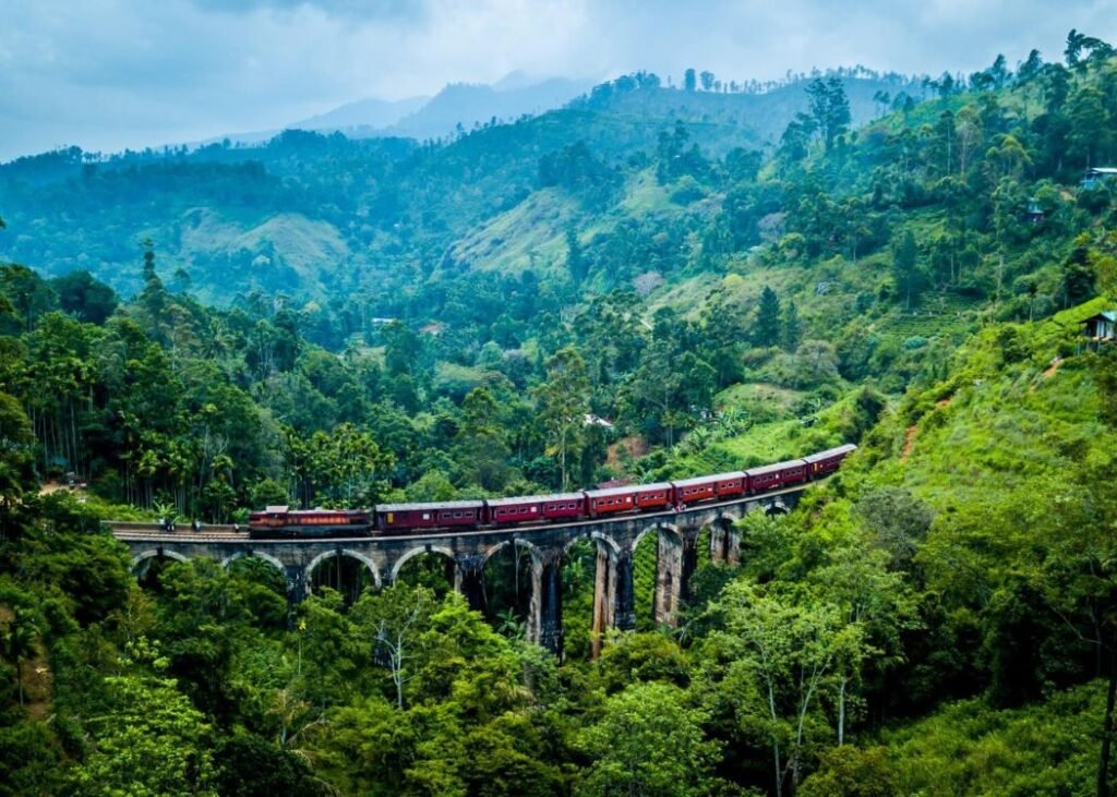 Red train crossing the Nine Arch Bridge in Ella, Sri Lanka