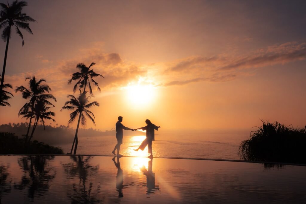 Couple on a palm-fringed beach at sunset