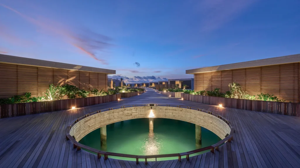 Circular overwater pool lit at dusk at Alila Kothaifaru