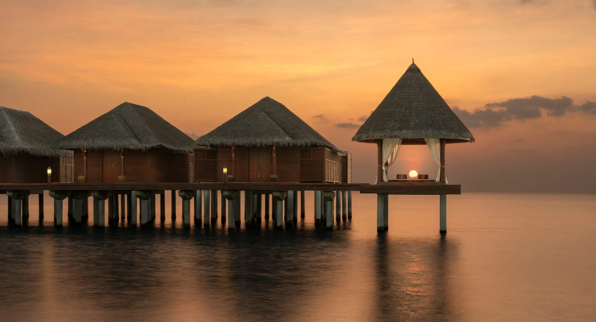 Overwater villas at sunset at Anantara Dhigu