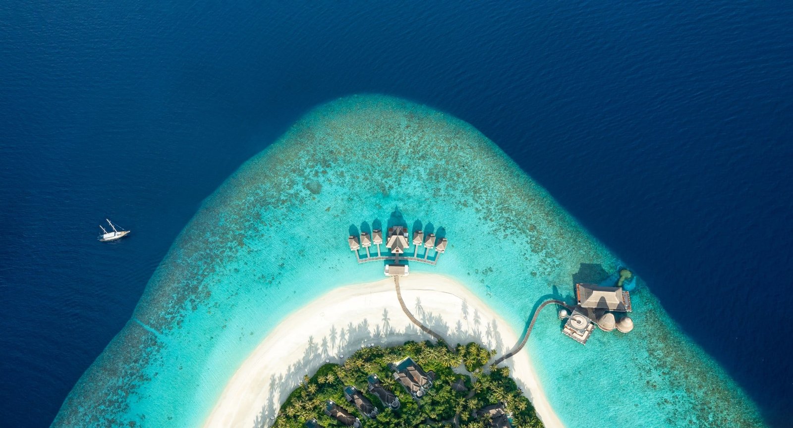 Aerial view of Anantara Kihavah island and its overwater villas