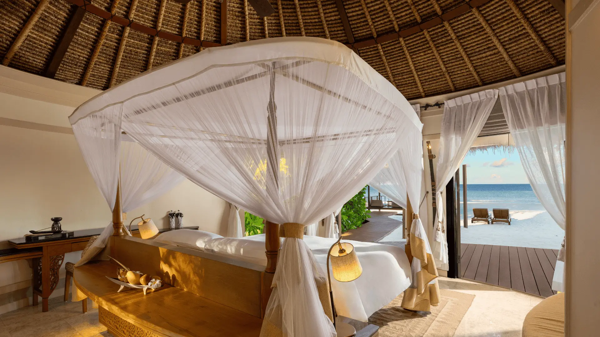 Four-poster bed with mosquito netting in a villa at Banyan Tree Vabbinfaru