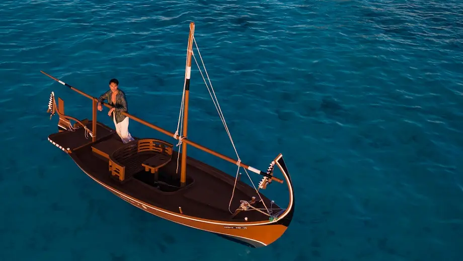 Traditional dhoni boat on turquoise water at Banyan Tree Vabbinfaru