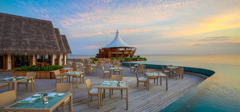 Overwater restaurant deck at sunset at Baros Maldives