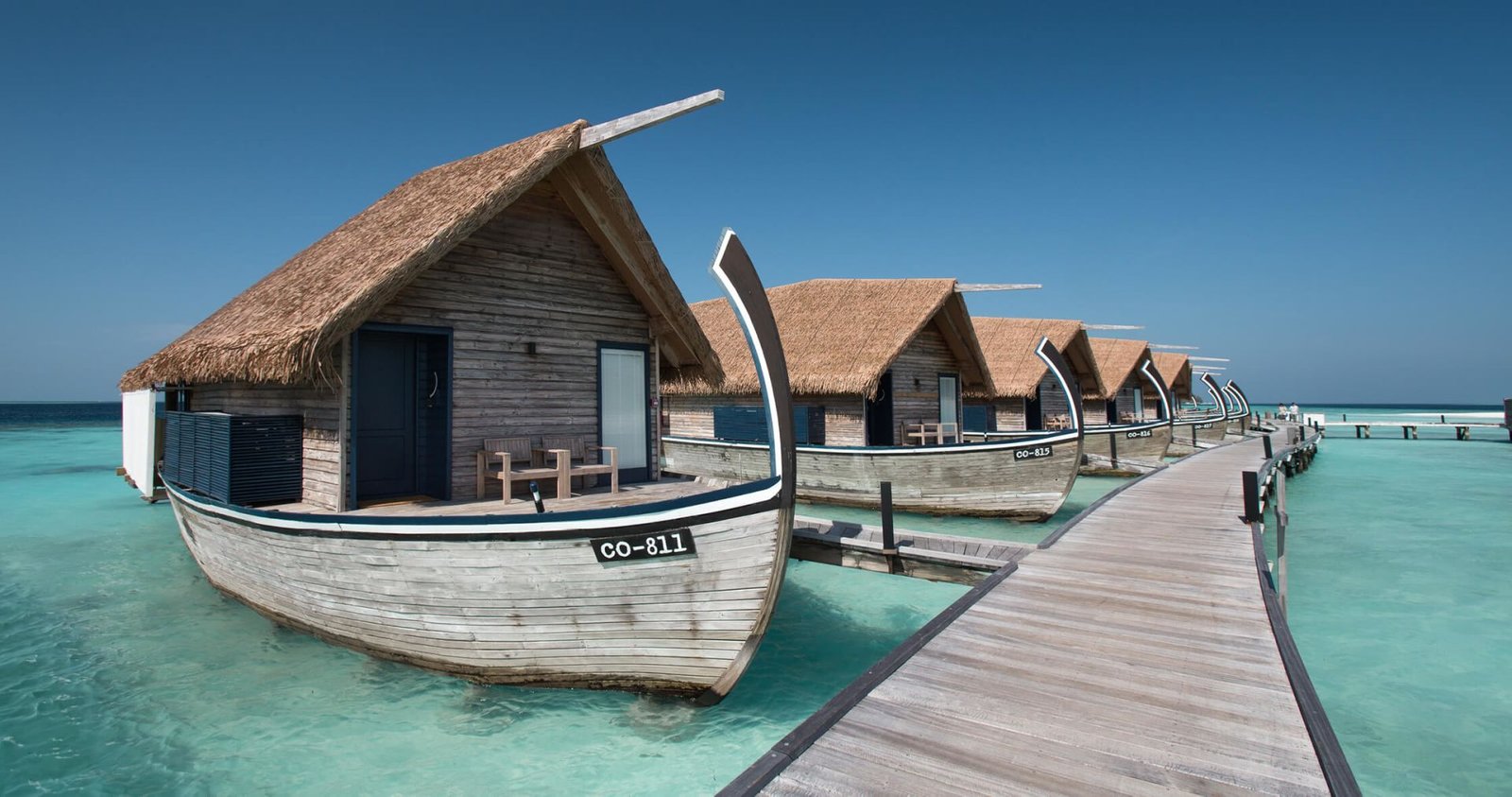 Dhoni boat moored beside the overwater villas at COMO Cocoa Island