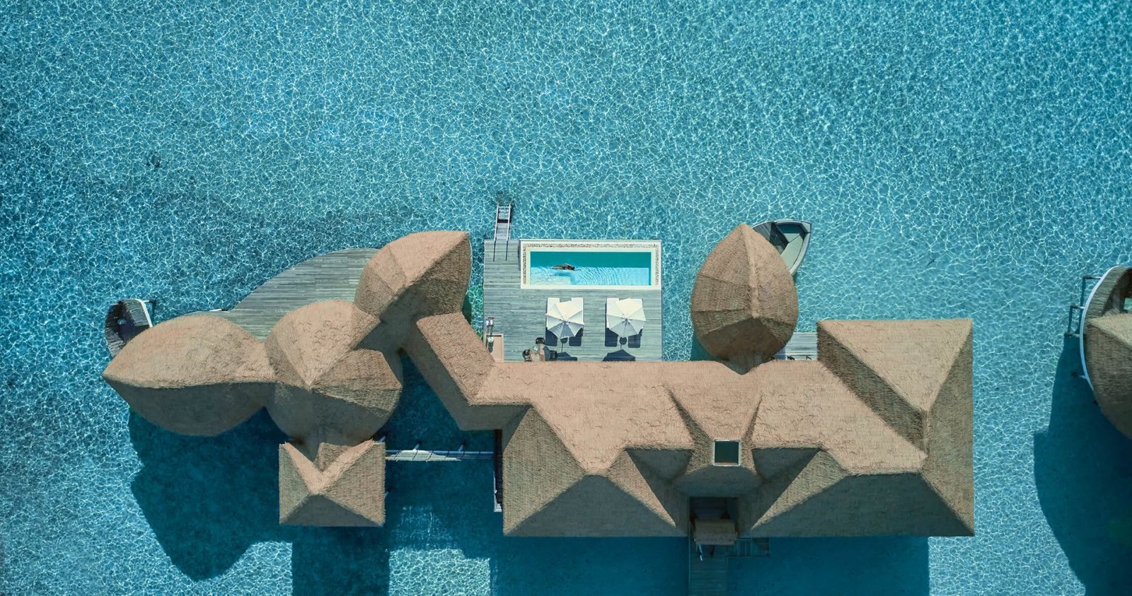 Aerial view of an overwater villa and pool at COMO Cocoa Island
