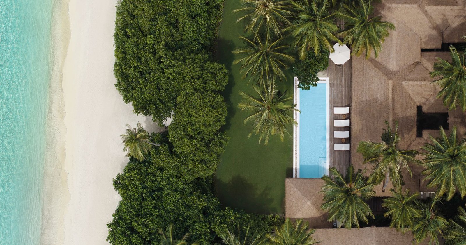 Aerial view of a villa and pool among the palms at COMO Maalifushi