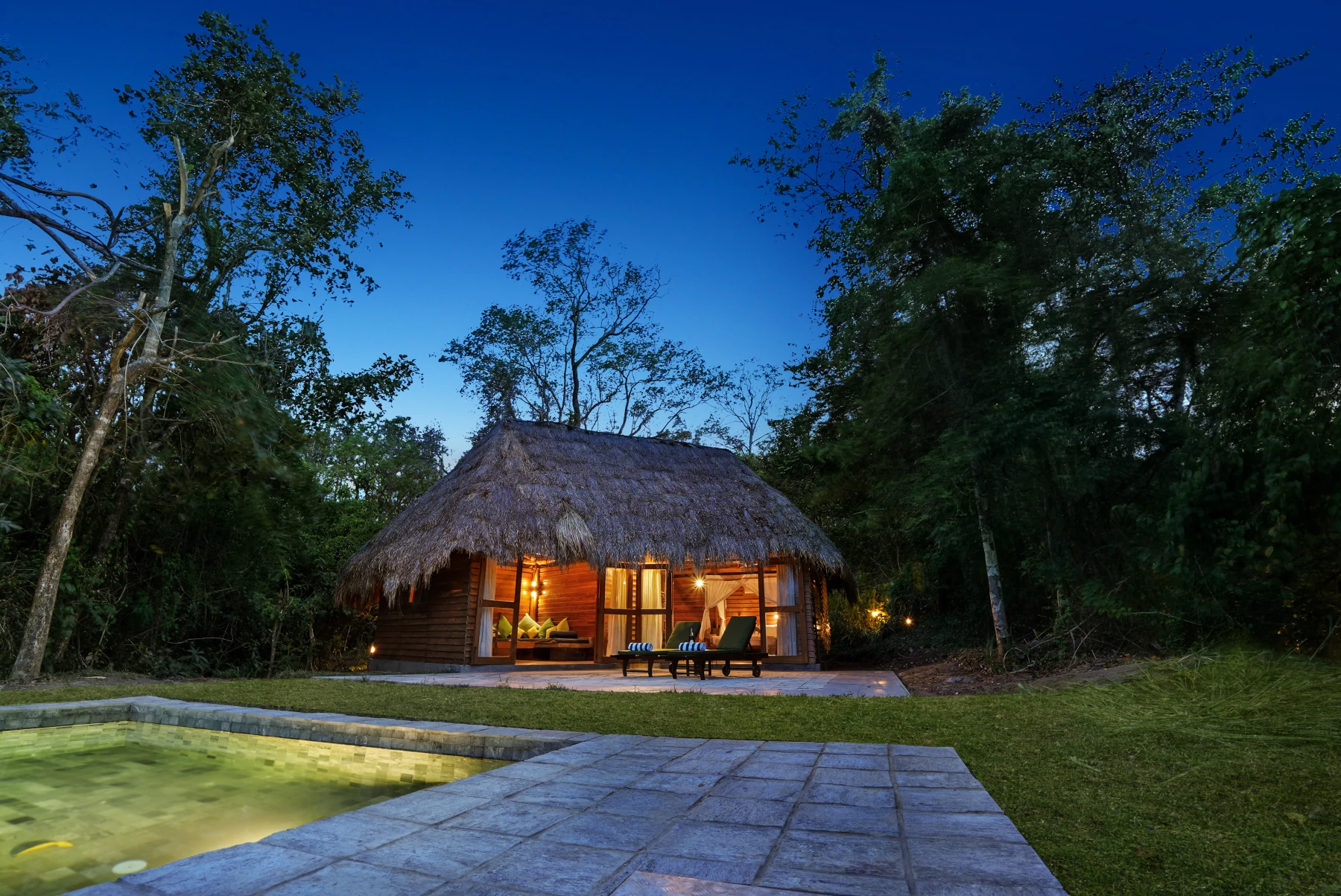 Lodge lit at dusk in the forest at Gal Oya Lodge