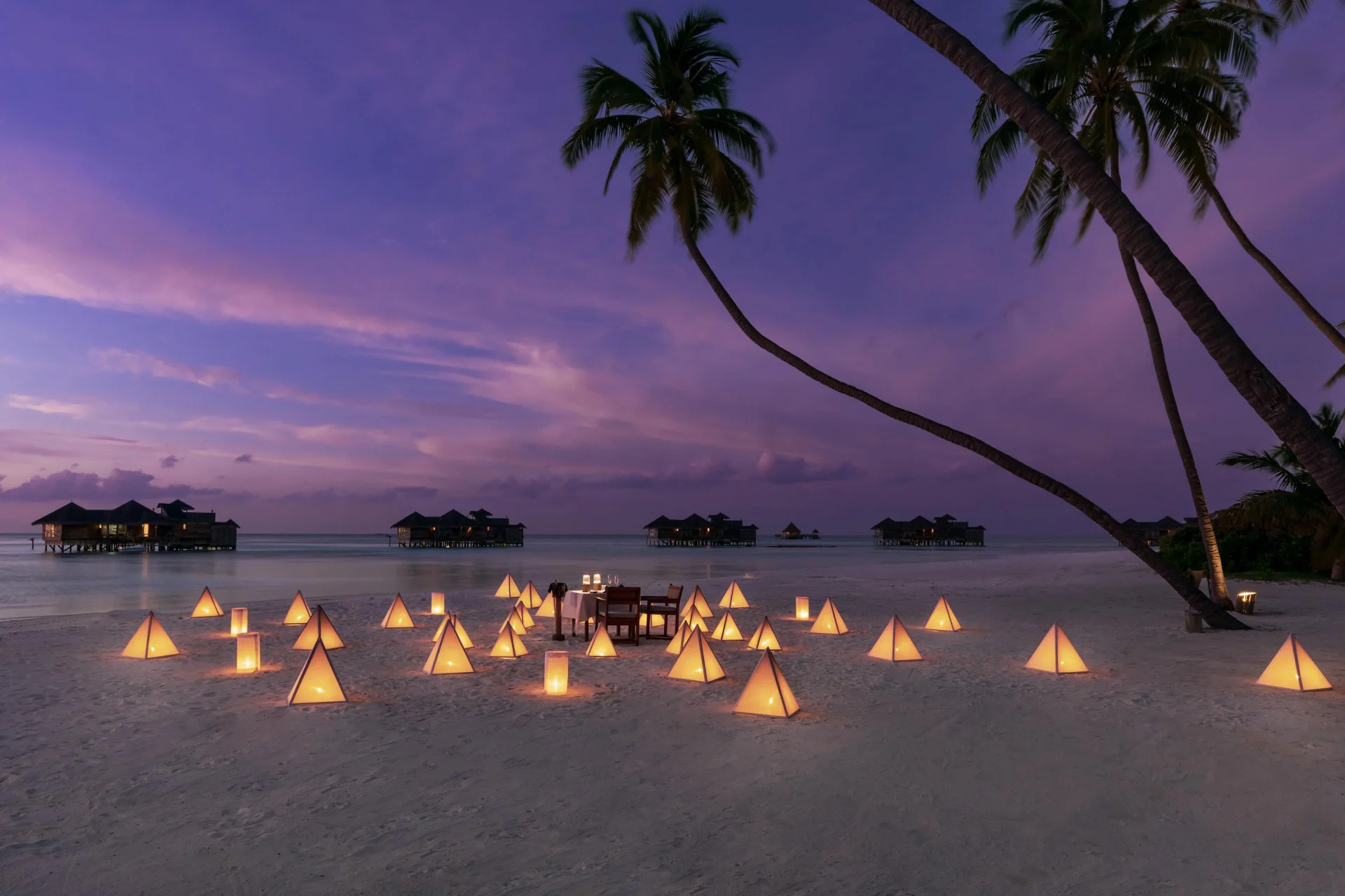 Beach lit with lanterns at dusk at Gili Lankanfushi