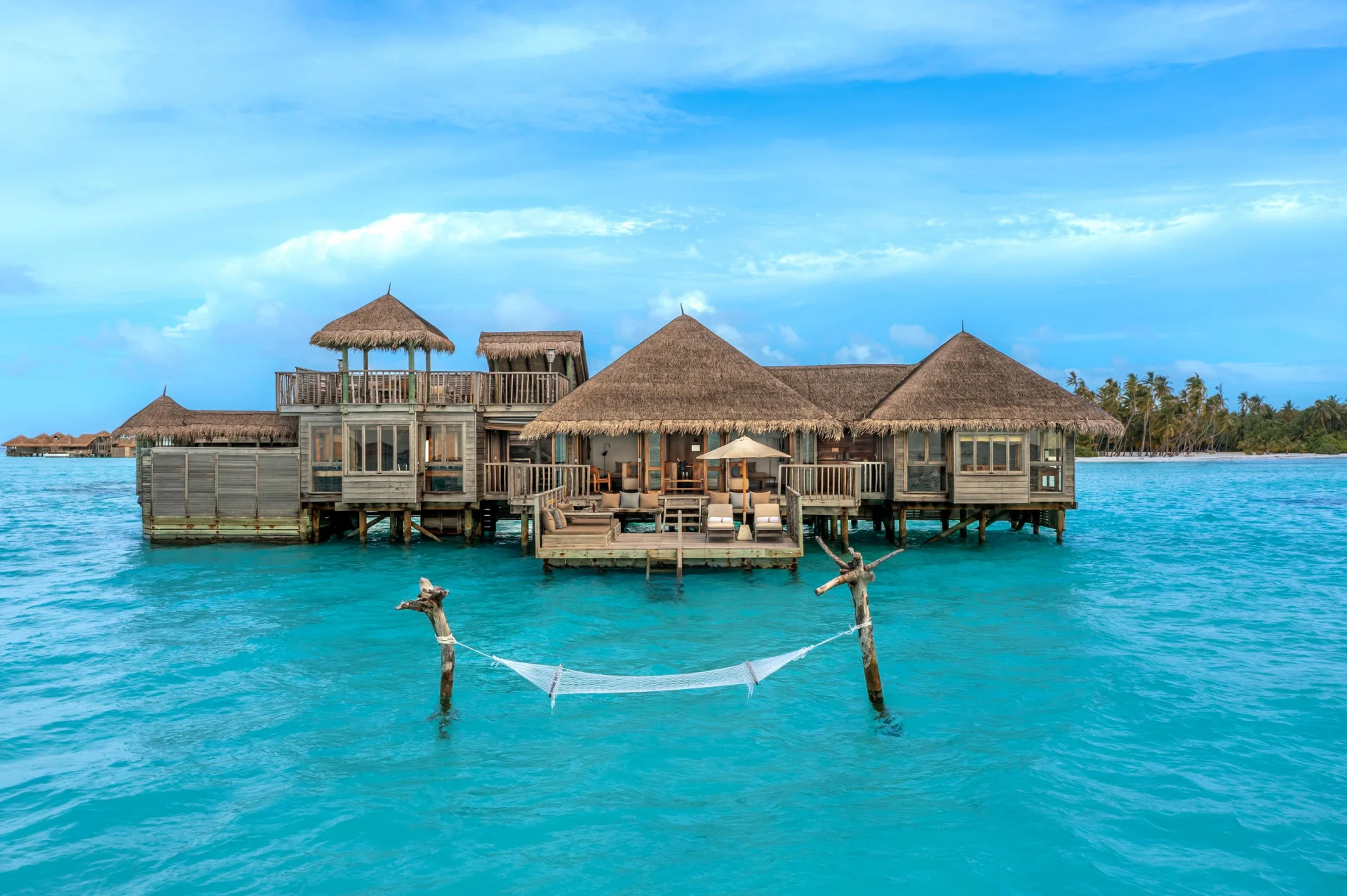 Guests in the lagoon beside an overwater villa at Gili Lankanfushi
