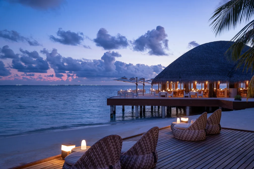Overwater dining pavilion at dusk at Huvafen Fushi