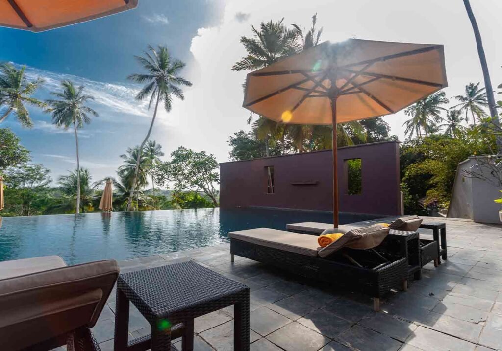 Pool, parasol and daybeds at Kahanda Kanda, Galle