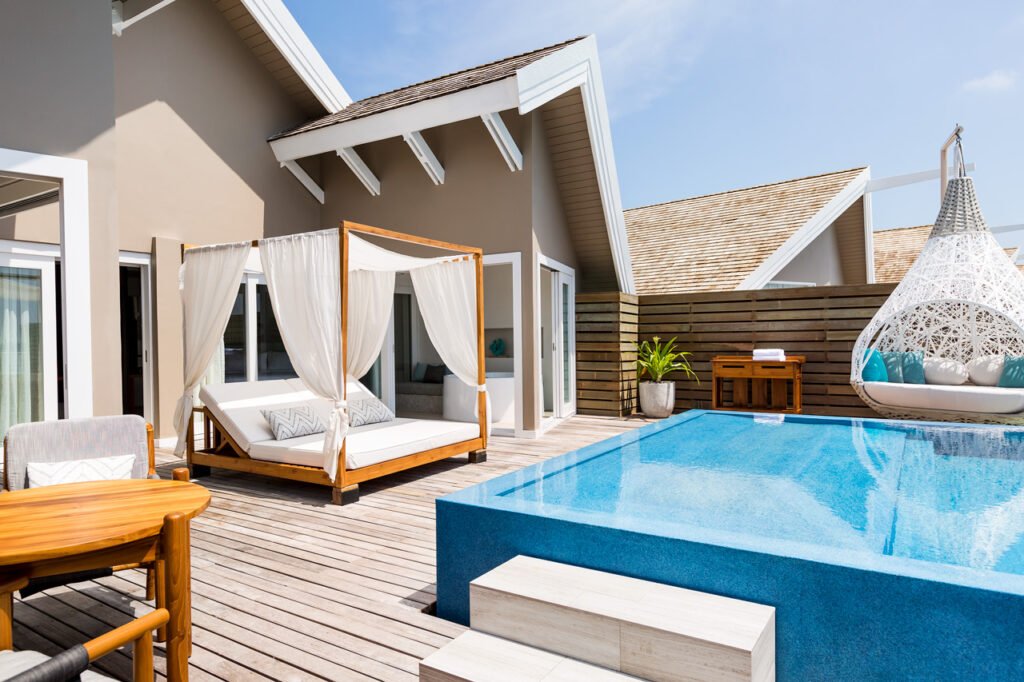 Villa deck with a daybed and private pool at LUX South Ari Atoll