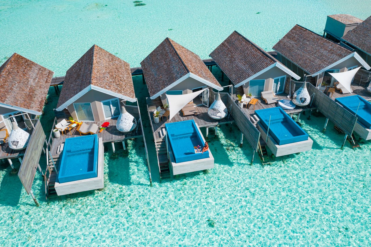 Overwater villas and loungers in the lagoon at Conrad Maldives Rangali Island