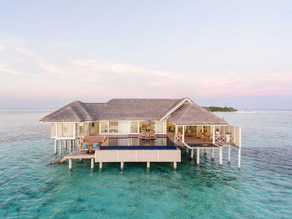 Overwater villa at sunset at LUX South Ari Atoll