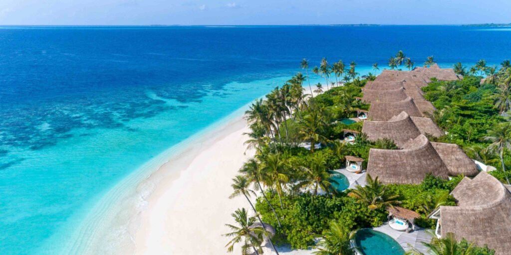 Beach and villas on the turquoise lagoon at Milaidhoo Island