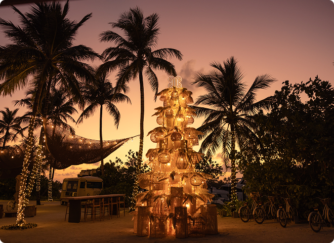 Palms and hammock lit at sunset at Patina Maldives