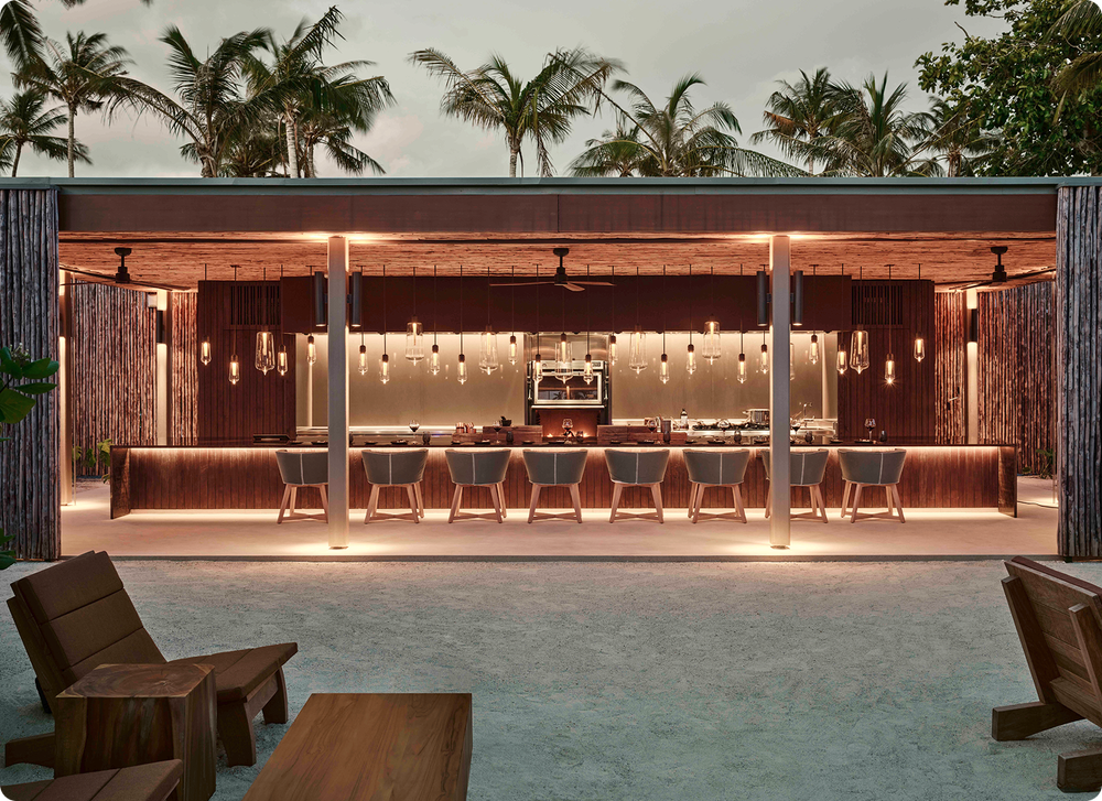 Beach bar at dusk at Patina Maldives