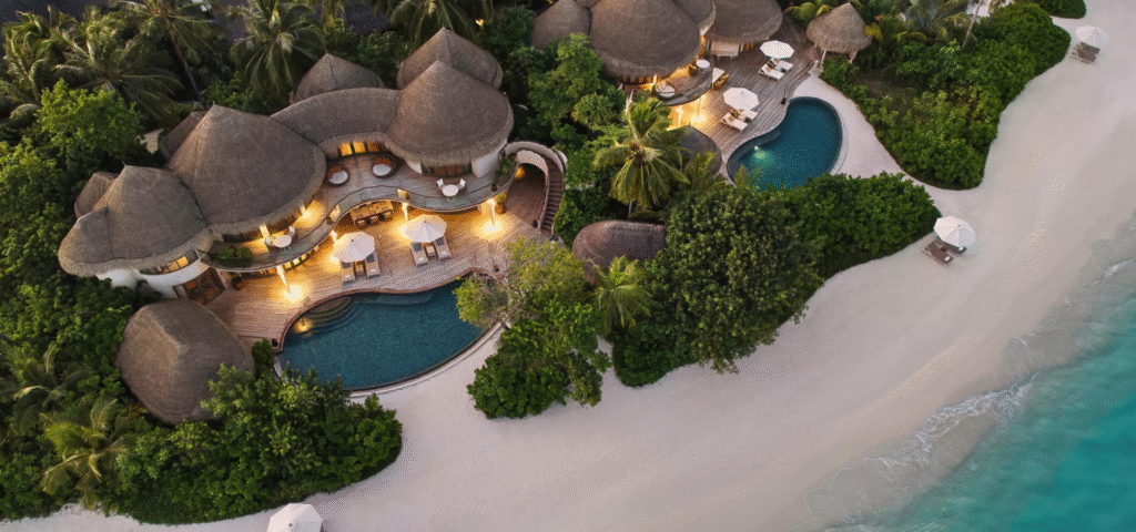 Aerial view of the thatched beach houses at The Nautilus Maldives