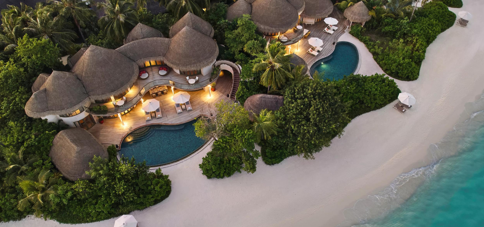 Aerial view of the thatched beach houses at The Nautilus Maldives