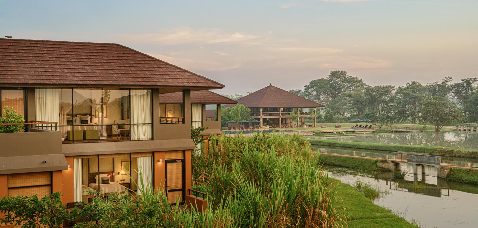 Villa lit at dusk beside the water at Water Garden Sigiriya